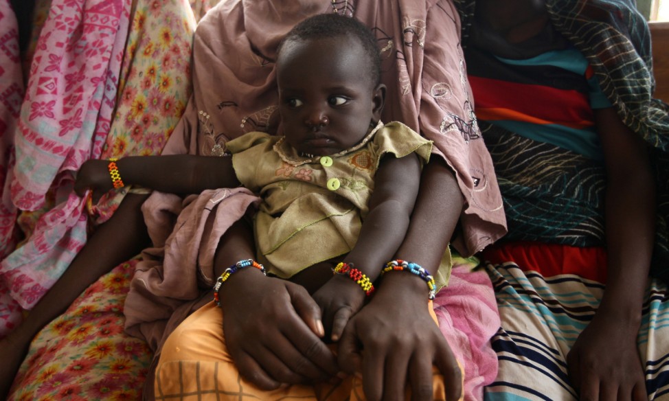 A woman holds her child as they wait to receive treatment in Kobo health center in Kobo village, one of the drought stricken areas of Oromia region, in Ethiopia