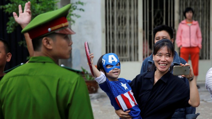 A kid dressed as Captain America waves at U.S. President Barack Obama's motorcade during Obama's arrival at Ho Chi Minh City