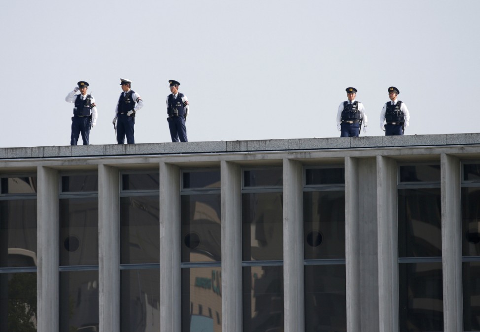 Police officers stand guard atop of a building before Obama's arrival at Hiroshima Peace Memorial Park and Museum