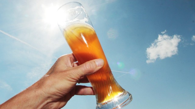 Glas mit Weizenbier an einem heißen Sommertag mit blauem Himmel in einem Biergarten am Titisee Bade