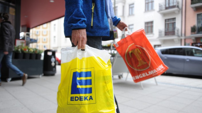 Mann mit Einkaufstüten von Edeka und Tengelmann, 2015