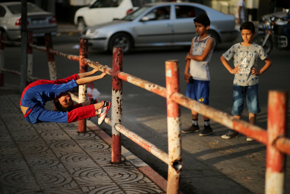 Palestinian boy Mohamad al-Sheikh, 12, who is nicknamed 'Spiderman' and hopes to break the Guinness world records with his bizarre feats of contortion, demonstrates acrobatics skills in Gaza City