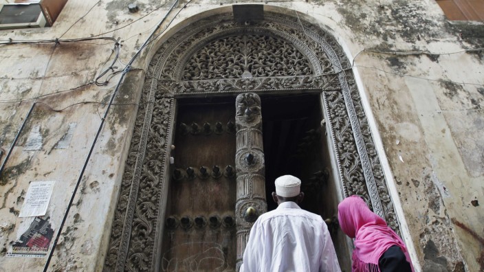 Muslim faithfuls enter a building in the historic centre of Stone Town in the Indian Ocean Island of Zanzibar