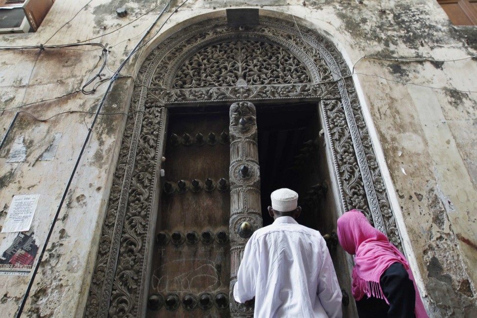 Muslim faithfuls enter a building in the historic centre of Stone Town in the Indian Ocean Island of Zanzibar