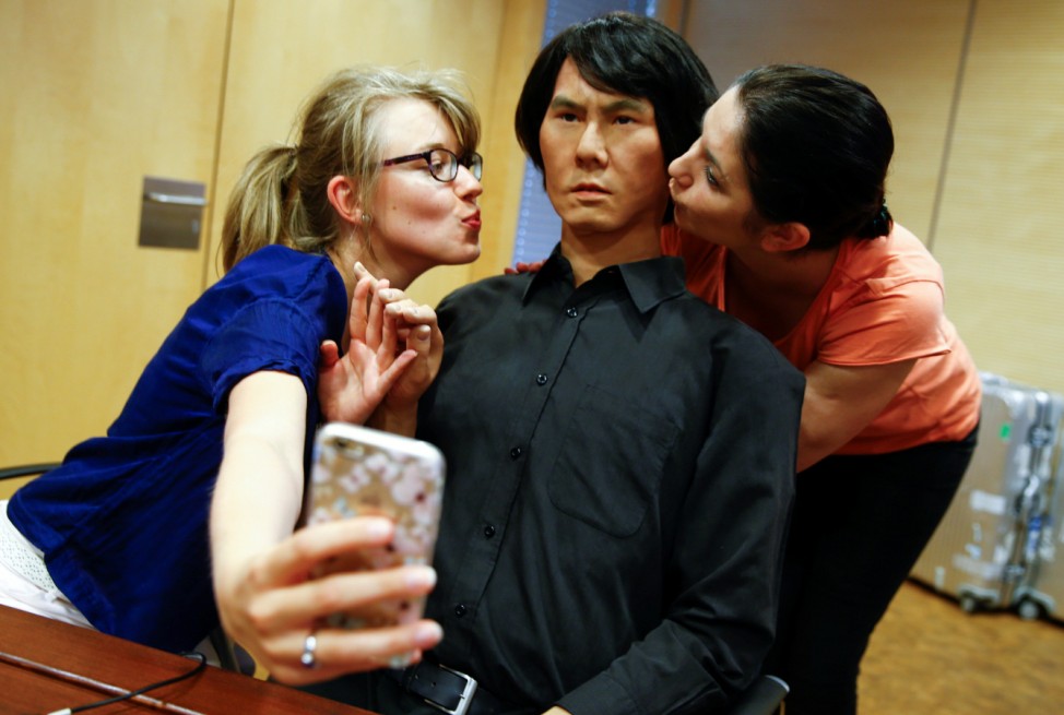 People take a selfie with life-size humanoid robot HI-4 in Duesseldorf