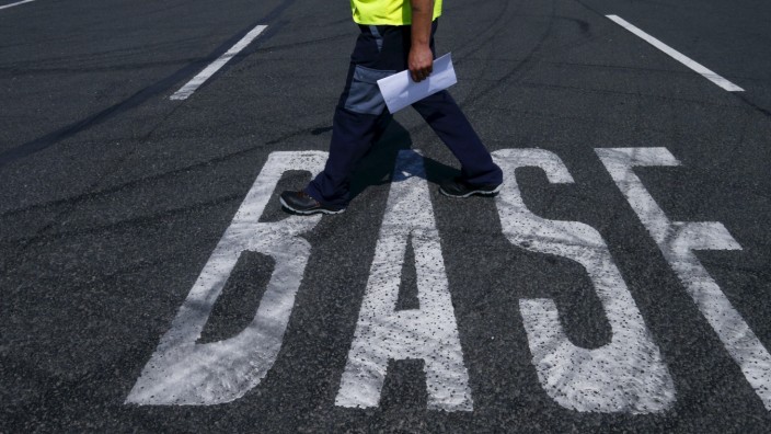 A truck driver walks along a BASF sign on the road near the warehouse of German chemical company BASF in Ludwigshafen