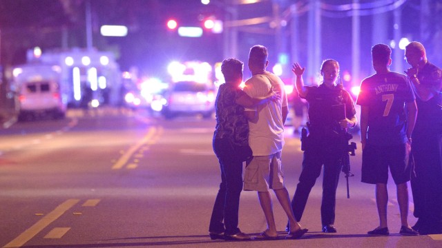 Schießerei  in Orlando: Schreckensnacht: Polizisten halten Angehörige der Nachtclub-Gäste in Orlando davon ab, dem Tatort zu nahe zu kommen.