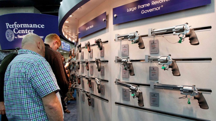 Gun enthusiasts look over Smith & Wesson guns at the National Rifle Association's annual meetings and exhibits show in Louisville