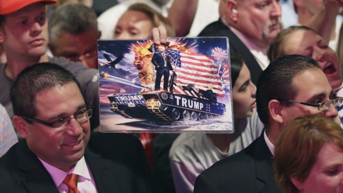US-Wahlkampf: Verliert der Feldzug an Stoßkraft? Ein Anhänger Donald Trumps hält ein Foto, das den Kandidaten auf einem Panzer zeigt.