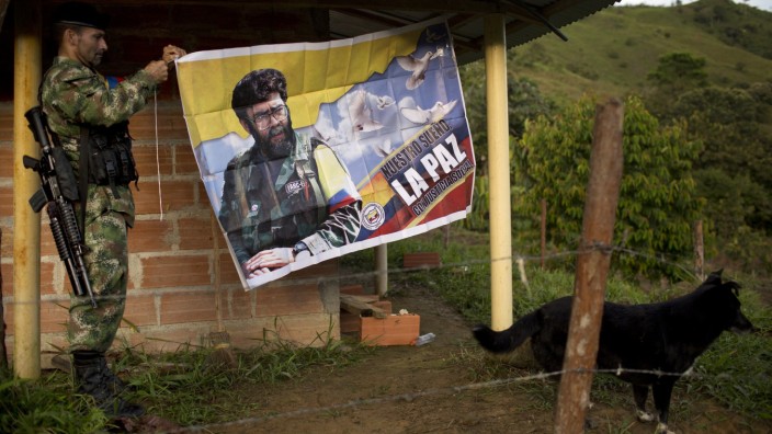 Bürgerkrieg: Ein Kämpfer der Front of the Revolutionary Armed Forces of Colombia (Farc) vor einer Fahne mit der Botschaft "Unser Traum ist Frieden mit sozialer Gerechtigkeit" in einem versteckten Guerilla-Camp in den Anden.