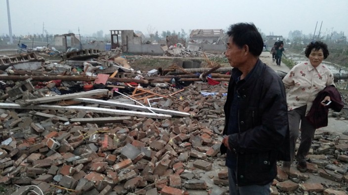 A man stands on debris of houses after a tornado hits Funing county, Yancheng