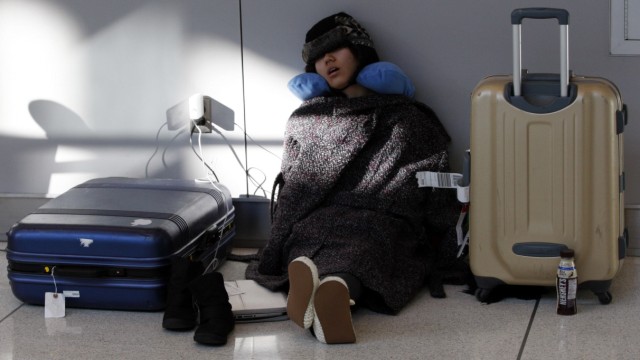 A passenger sleeps at JFK International Airport as she waits for the airport to reopen in New York