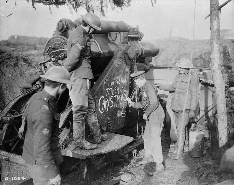 Canadian archive photo shows a gunnery officer writing a Christmas message on a Canadian heavy howitzer during the Battle of the Somme