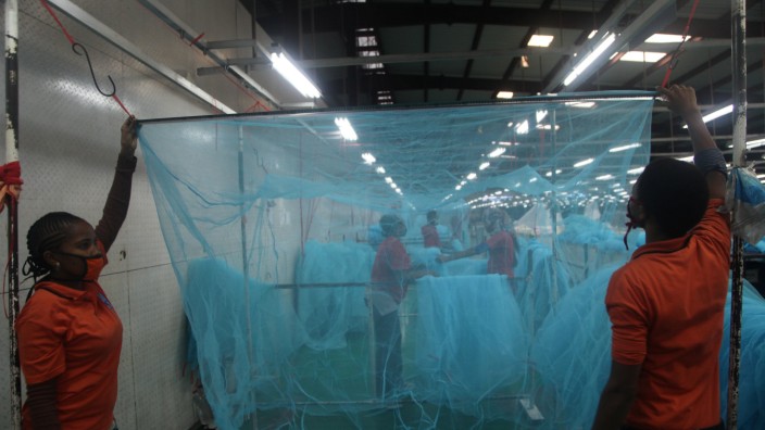 Workers look for abnormal holes in mosquito netting at the A to Z Textile Mills factory producing insecticide-treated bednets in Arusha, Tanzania