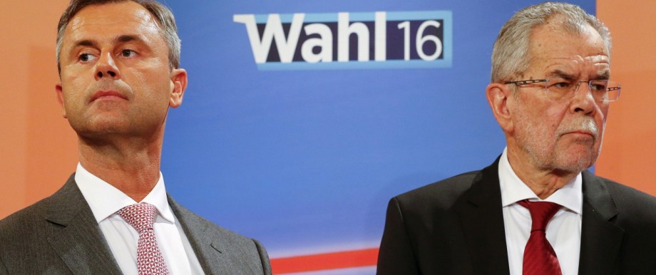 Presidential candidates Van der Bellen and Hofer react during a TV debate in Vienna