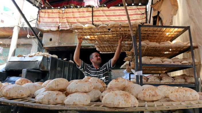 An Egyptian baker is seen beside a vegetable market in Cairo