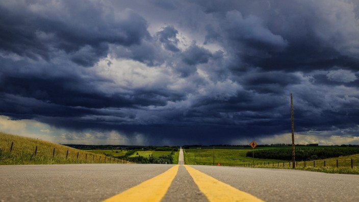 Klimaforschung: Sturmwolken ballen sich über einem Highway in der kanadischen Provinz Alberta zusammen.