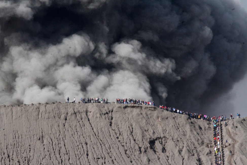 People standing on the edge of the crater while watching the eruption of Mount Bromo in Probolinggo