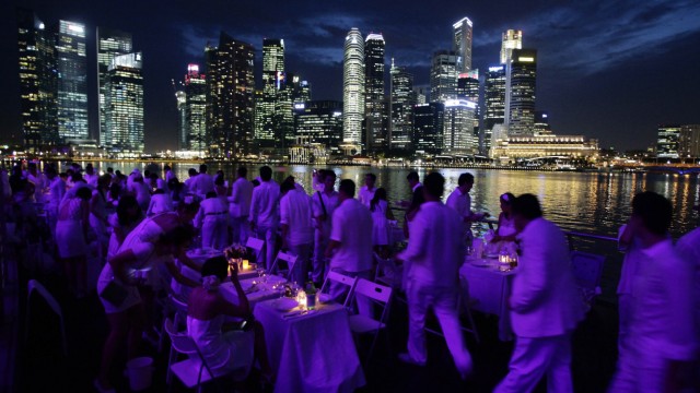 People arrive at the 'Diner en blanc' event outside the ArtScience Museum at the Marina Bay Sands in Singapore