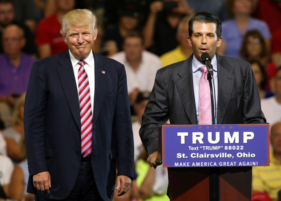 Republican U.S. presidential candidate Donald Trump smiles as his son Donald Trump Jr. speaks for a moment at a campaign rally in St. Clairsville, Ohio