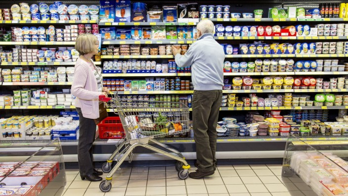 Supermarkt Lebensmittel älteres Seniorenpaar beim einkaufen Kühlregal mit Milch Molkerei Produkte