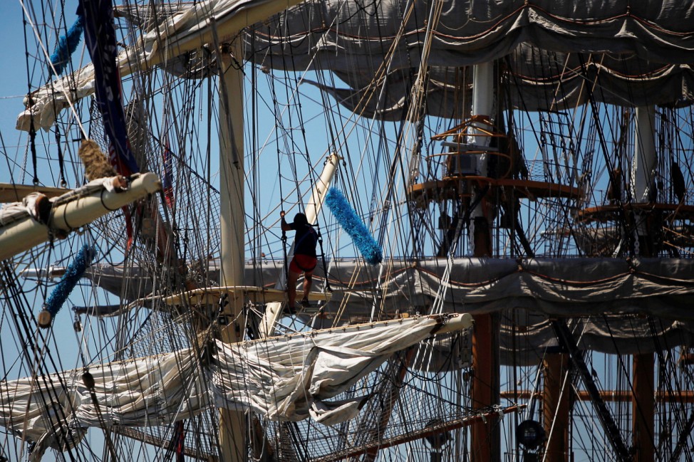 Crew members prepare a ship before the beginning of the Tall Ships Races 2016 parade, in Lisbon