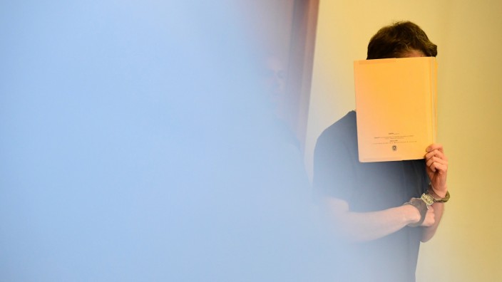 Potsdam: Silvio S. versteckt im Potsdamer Gerichtssaal sein Gesicht hinter einer Aktenmappe.