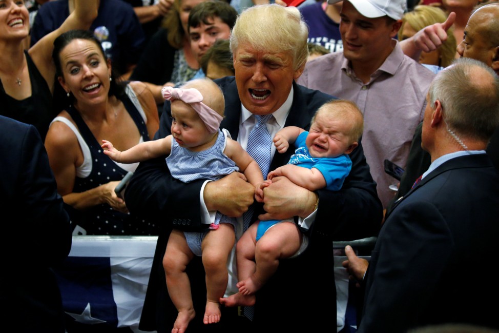 Republican presidential nominee Donald Trump holds babies at a campaign rally in Colorado Springs,