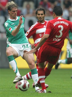 Muenchens Lucio stoppt Bremens Tim Borowski, in der Mitte Muenchens Hamit Altintop. Foto: ddp