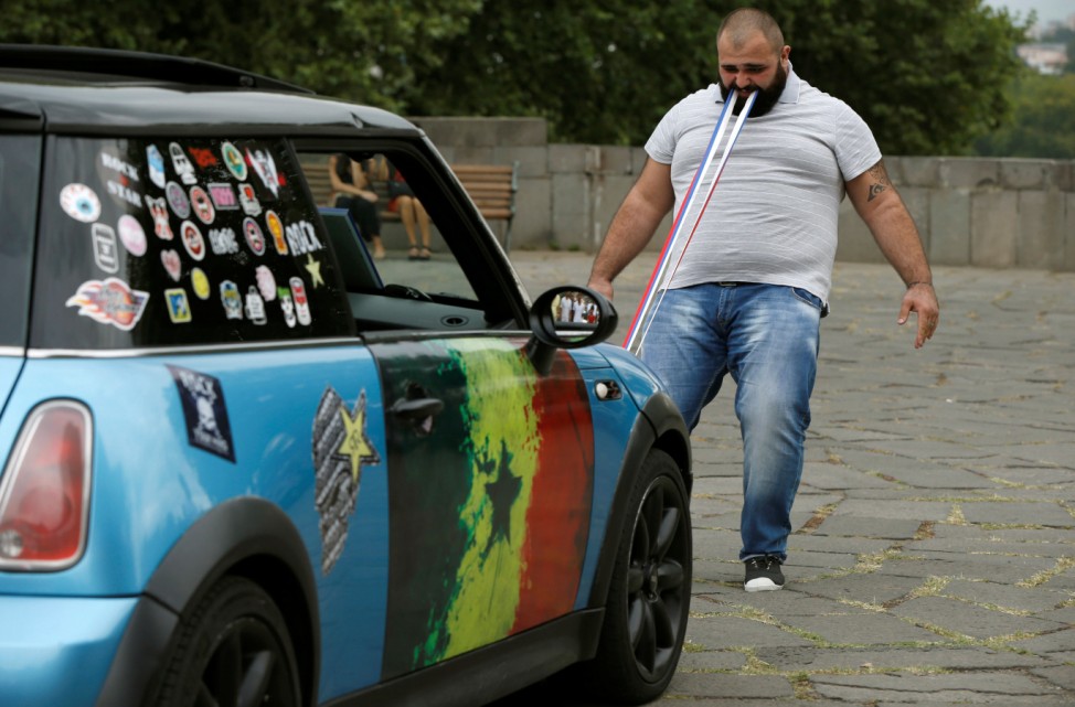 Ustiashvili pulls four cars with his teeth during an attempt to set a world record in Tbilisi