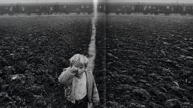 Umgang mit Flüchtlingen: Ein kleiner Junge im Flüchtlingslager Ivankovo in Ostkroatien, 1994. Die Waggons des ausrangierten Zuges im Hintergrund wurden von der Hilfsorganisation Cap Anamur bewohnbar gemacht.