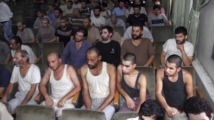 Krieg in Syrien: Sie haben überlebt: Diese syrischen Männer warteten im Jahr 2012 in einem Gerichtssaal in Damaskus auf ihre Freilassung aus dem Gefängnis.