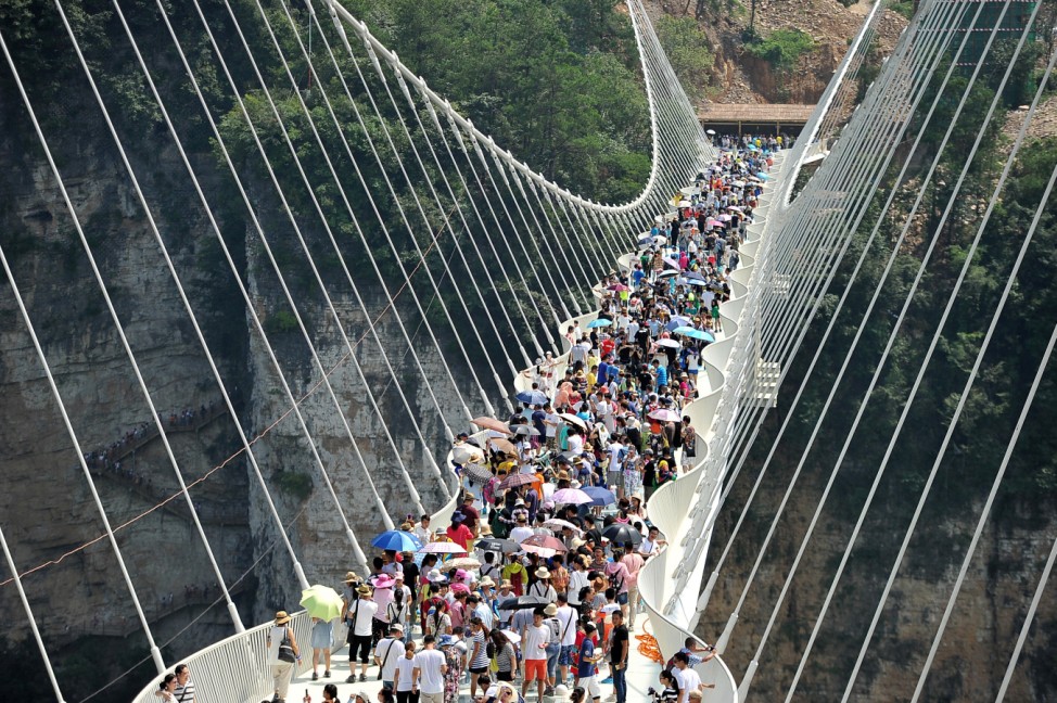 People visit a glass bridge at a gorge as it opens to public in Zhangjiajie