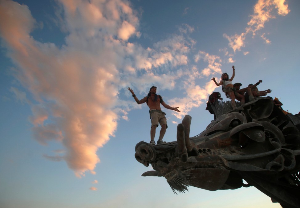 Participants dance and climb on an art installation as approximately 70,000 people from all over the world gather for the 30th annual Burning Man arts and music festival in the Black Rock Desert of Nevada, U.S.