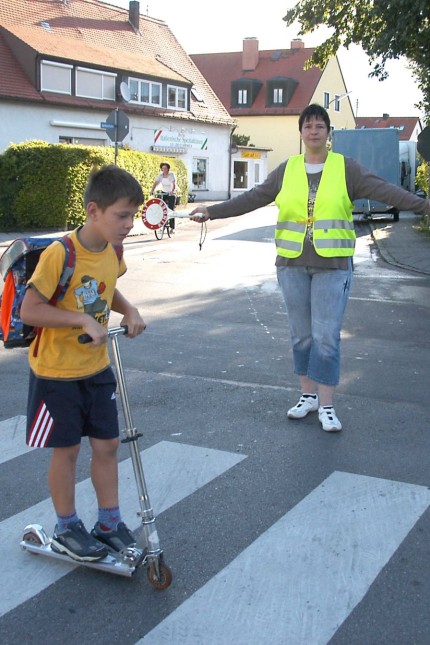 Schulweghelfer: Mit Warnweste und Signalkelle ausgestattet sorgt Angelika Schmerak dafür, dass die Schulkinder sicher über die Straße kommen.