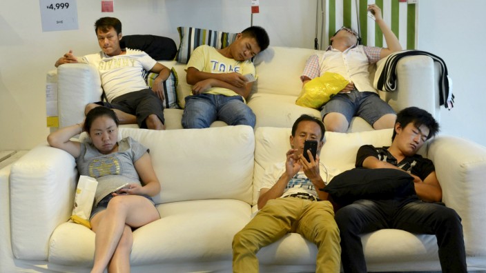 People rest and sleep on couches at a IKEA store to escape the summer heat in Hangzhou
