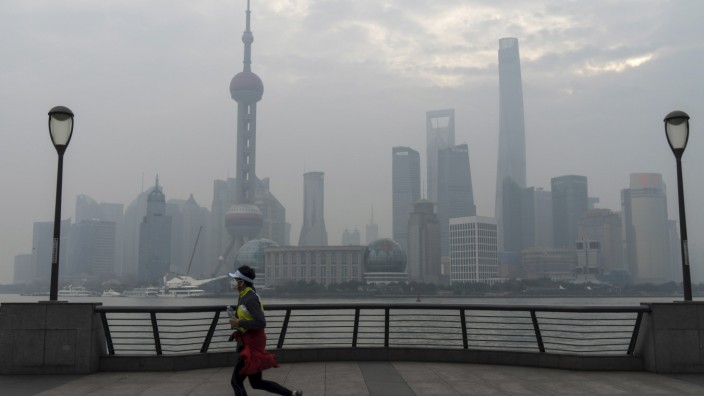 A jogger runs along the bund near the Huangpu river across the Pudong New Financial district, amid heavy smog in Shanghai