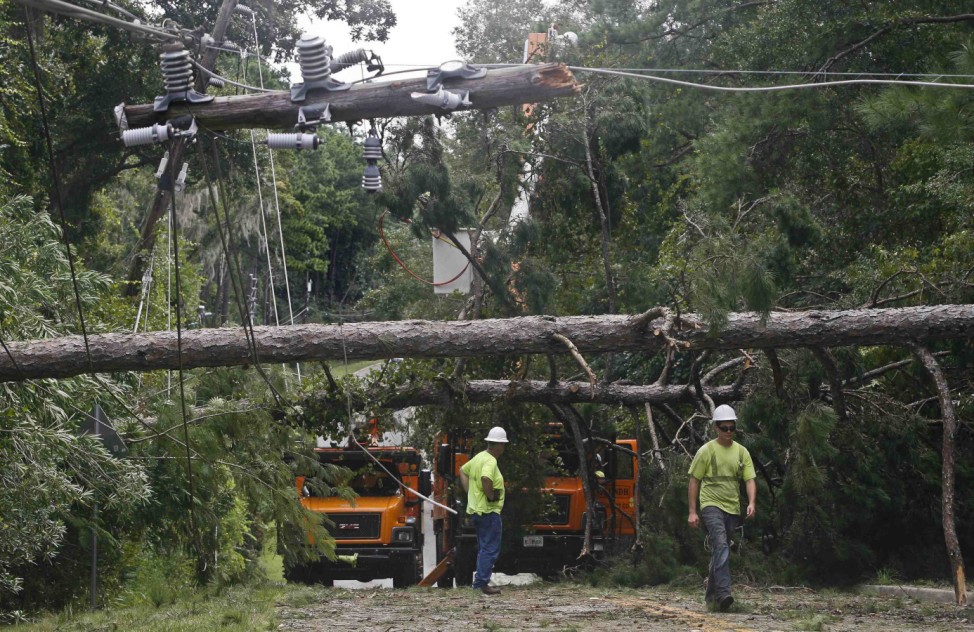 Workers remove downed trees during cleanup operations in the aftermath of Hurricane Hermine in Tallahassee
