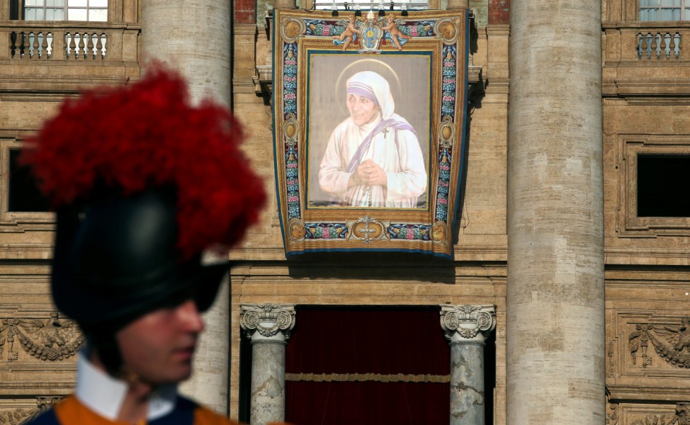 A Swiss Guard stands in front of a tapestry depicting Mother Teresa of Calcutta before a mass celebrated by Pope Francis for her canonisation in Saint Peter's Square at the Vatican