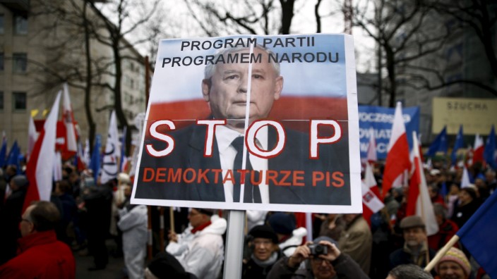 A man holds a banner with Jaroslaw Kaczynski, leader of ruling party Law and Justice (PiS) as he takes part in march demanding their government to respect the country's constitution in front of the Constitutional Court in Warsaw