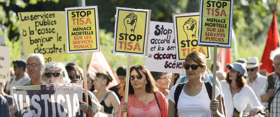 Demonstrators hold posters and banners during a rally against the