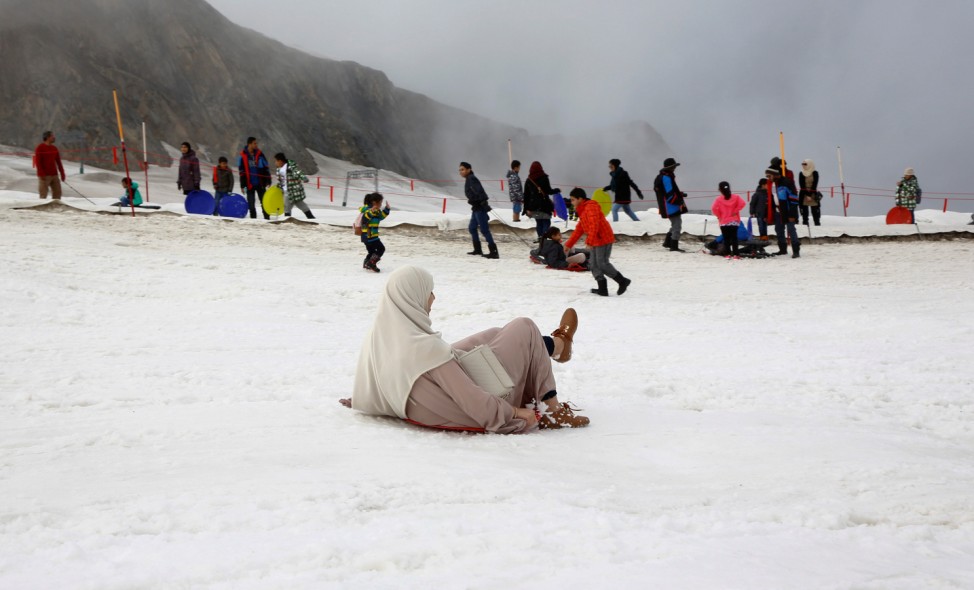 Arab tourists enjoy some snow on top of Kitzsteinhorn mountain near Zell am See