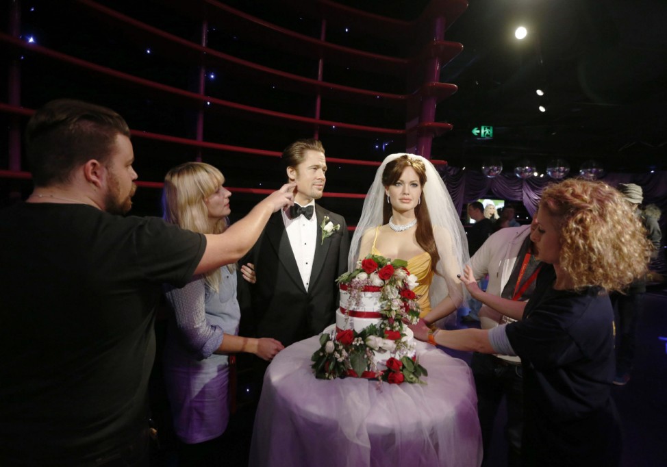 Wax models of actors Brad Pitt and Angelina Jolie are 'presented' with a wedding cake and bridal veil for Jolie in celebration of their wedding in Sydney