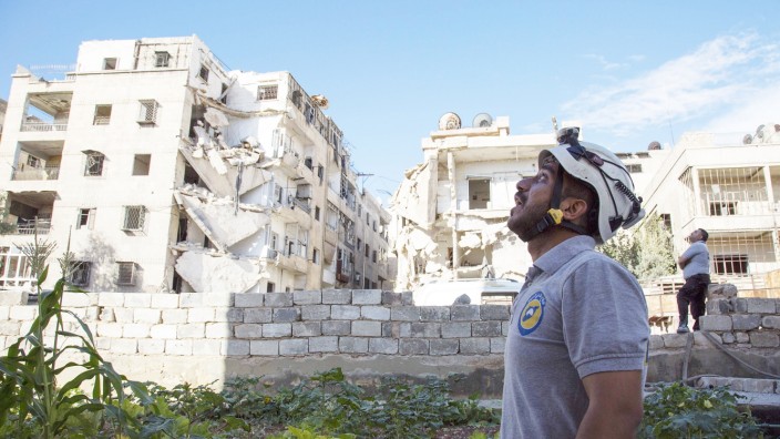 Syrien-Krieg: In Aleppo schaut ein syrischer Weißhelm-Sanitäter nach einem Luftangriff mit bangem Blick in den Himmel.