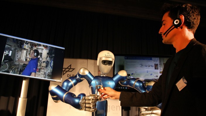 Mit ferngelenktem Roboterarm Hände schütteln; Händeschütteln mit Justin
