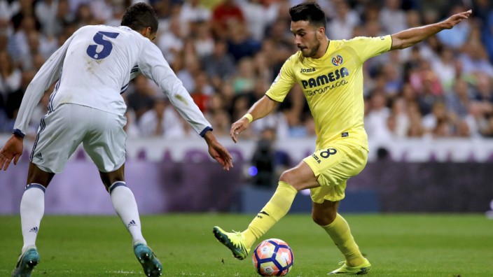 Real Madrid s French defense Raphael Varane L fights for the ball with Villarreal s Italian strile