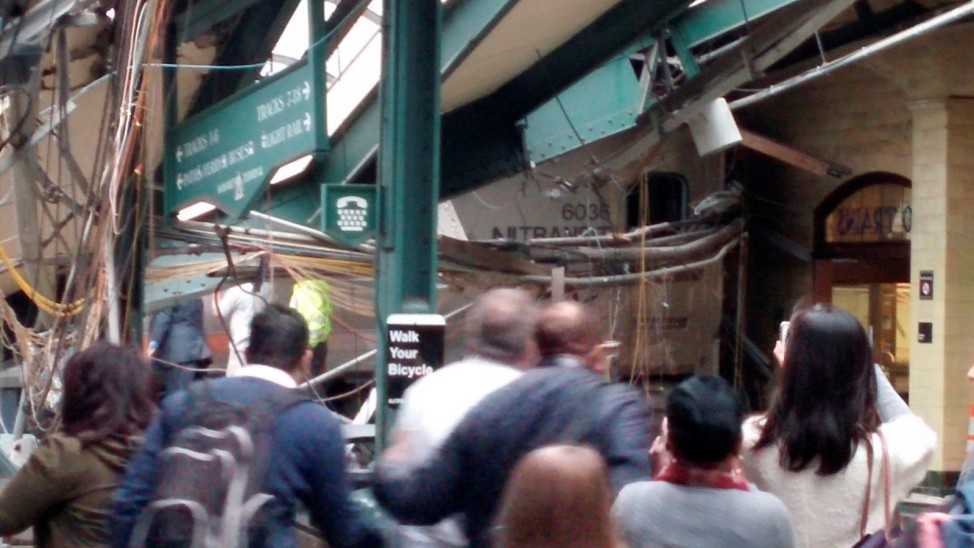Onlookers view a New Jersey Transit train that derailed and crashed through the station in Hoboken, New Jersey,
