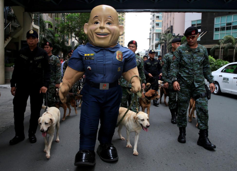 A mascot of the Philippine National Police (PNP), named after their Chief Director General Ronald Dela Rosa, marches with members of the K9 units and the Special Action Force before the mass blessing for rescue dogs in metro Manila
