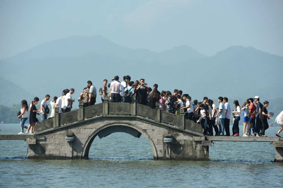 Visitors walk on a bridge on West Lake during China's golden week holiday in Hangzhou
