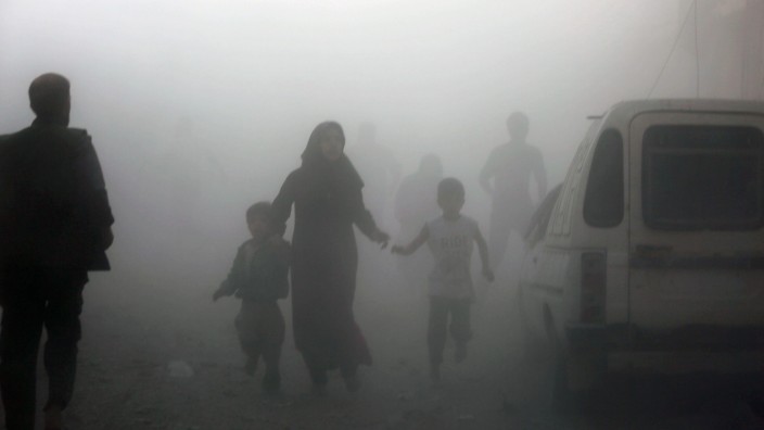 Syrien: Syrer fliehen nach einem Luftangriff in der Nähe von Damaskus durch den Staub.